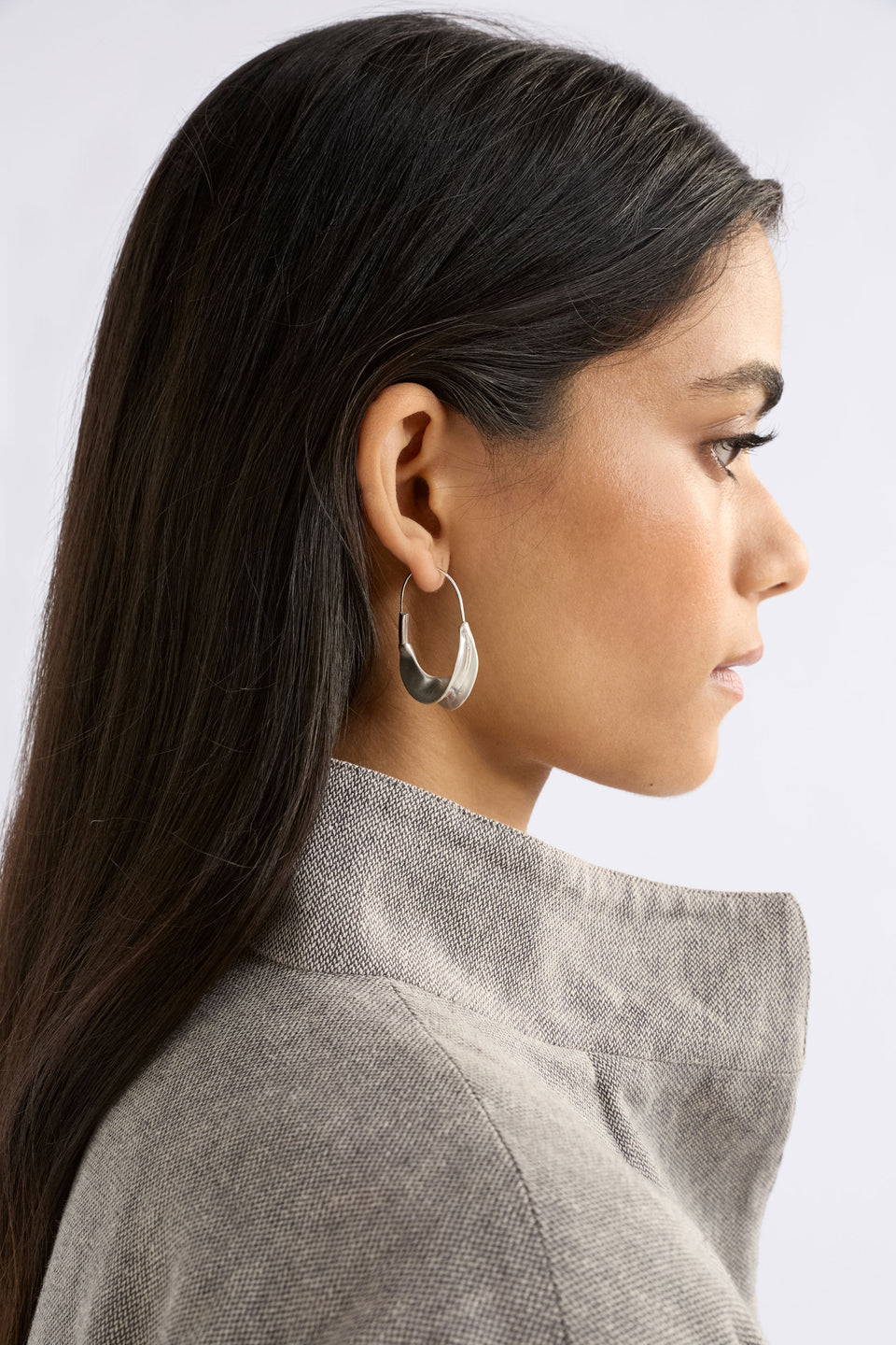 The Siita Hoop Earring features a sculptural petal-shaped base and fine closure for a modern take on the classic hoop shown on model | SILVER
