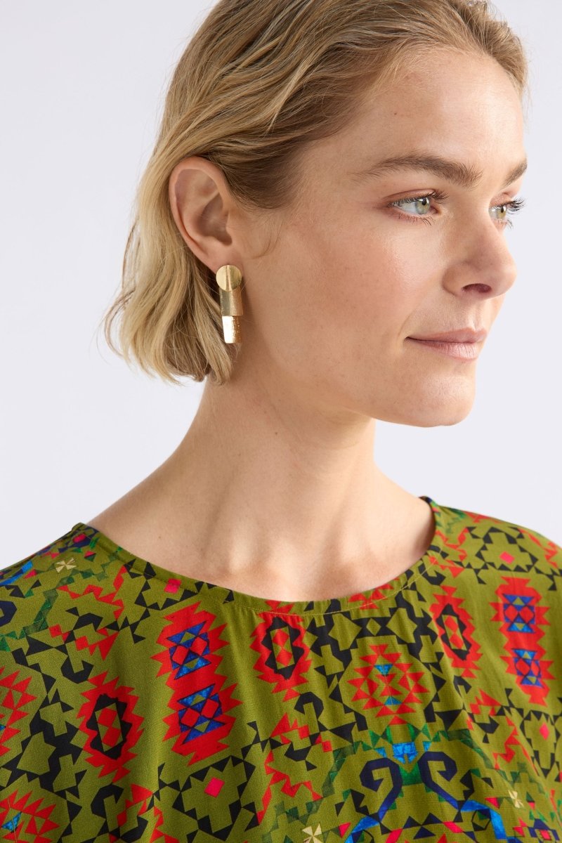 The Paerr Drop Earring features two rounded rectangles and a circle in a vertical row, creating a mid-sized sculptural drop style on model ELK | GOLD