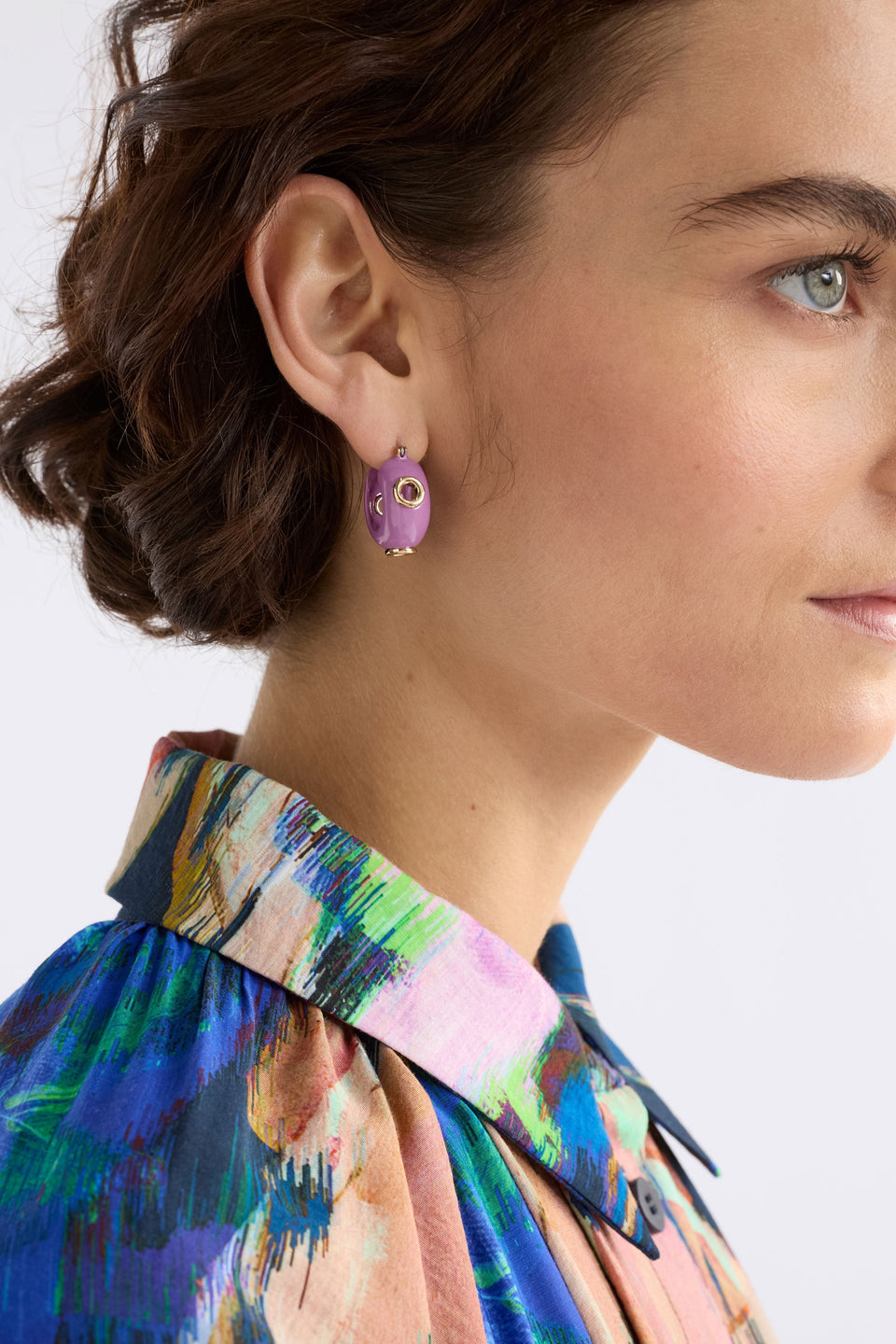 The Jans Hoop Earring features a chunky mini hoop silhouette with glossy enamel and metallic rivet detailing for a bold, playful finish, shown on model | LILAC