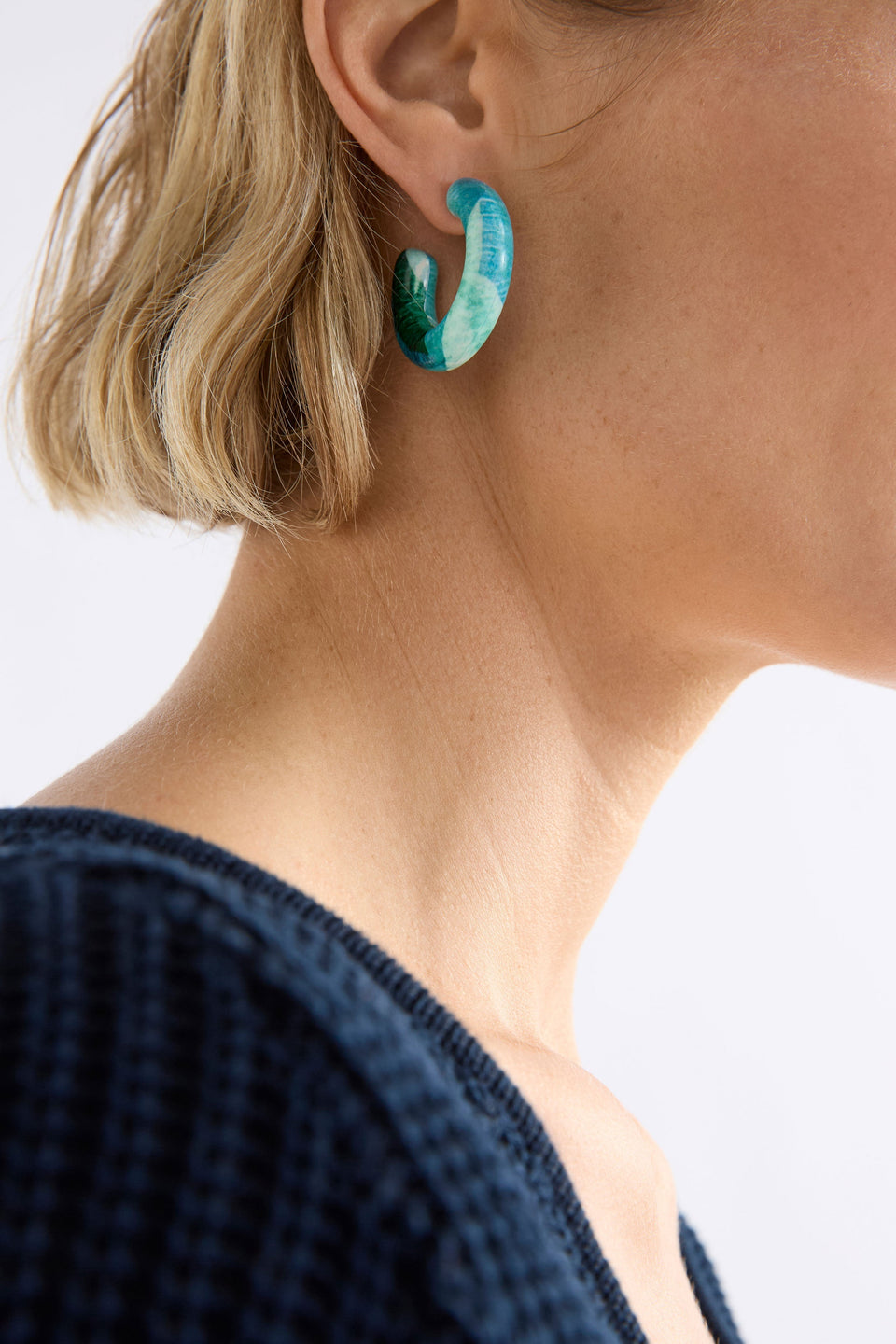 The Resso Hoop Earring features a mid-sized open resin hoop with a contemporary silhouette and playful all-over printed design, shown on model | GREEN KOMI PRINT