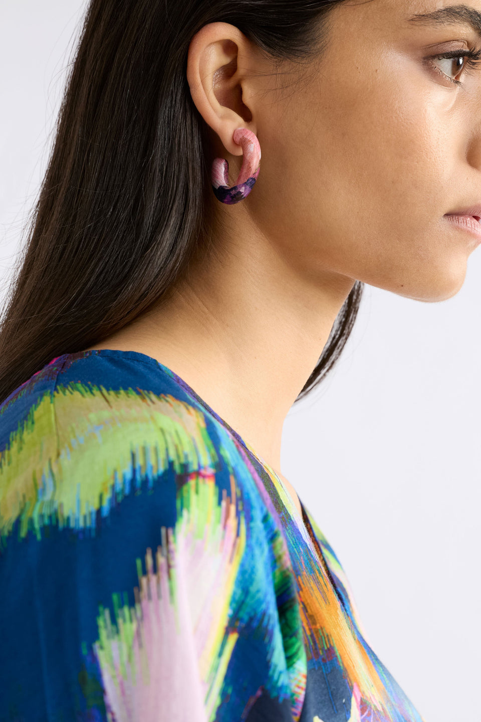 The Resso Hoop Earring features a mid-sized open resin hoop with a contemporary silhouette and playful all-over printed design, shown on model | FUSCHIA KOMI PRINT