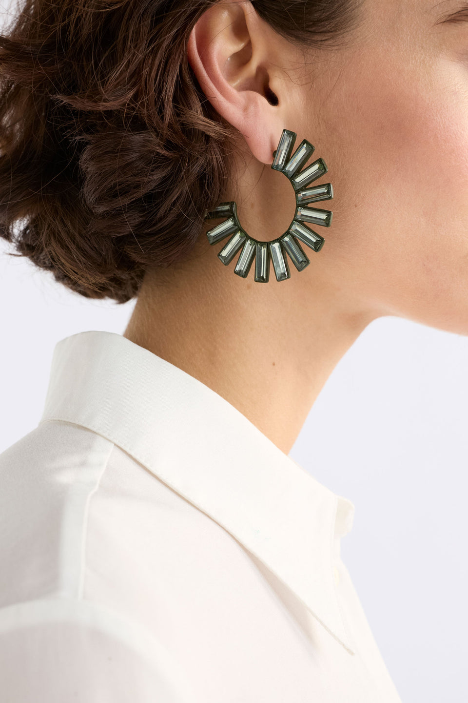 The Jule Large Hoop Earring features a circular fan of tonal glass beads radiating from a large hoop for a fun, glistening statement on model ELK | DARK OLIVE