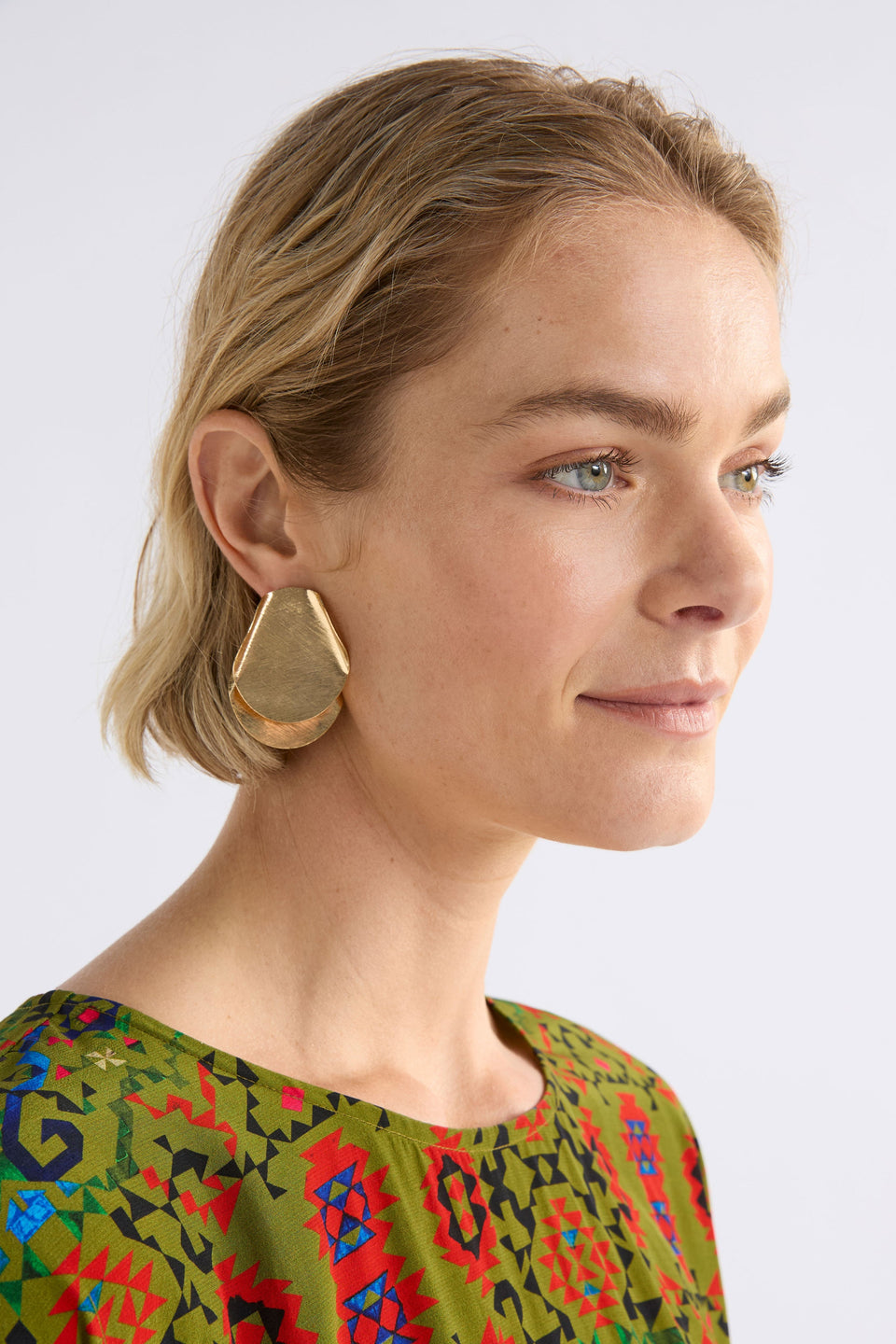 The Villt Earring features two overlapping petal-like forms crafted from fine, shiny metal for a lightweight sculptural statement ELK | GOLD