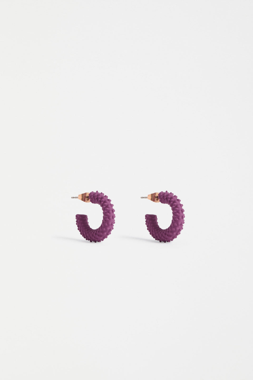 The Ekstaa Mini Hoop Earring features a textured small hoop design with a soft matte rubberised finish in bold colourways ELK | MULBERRY