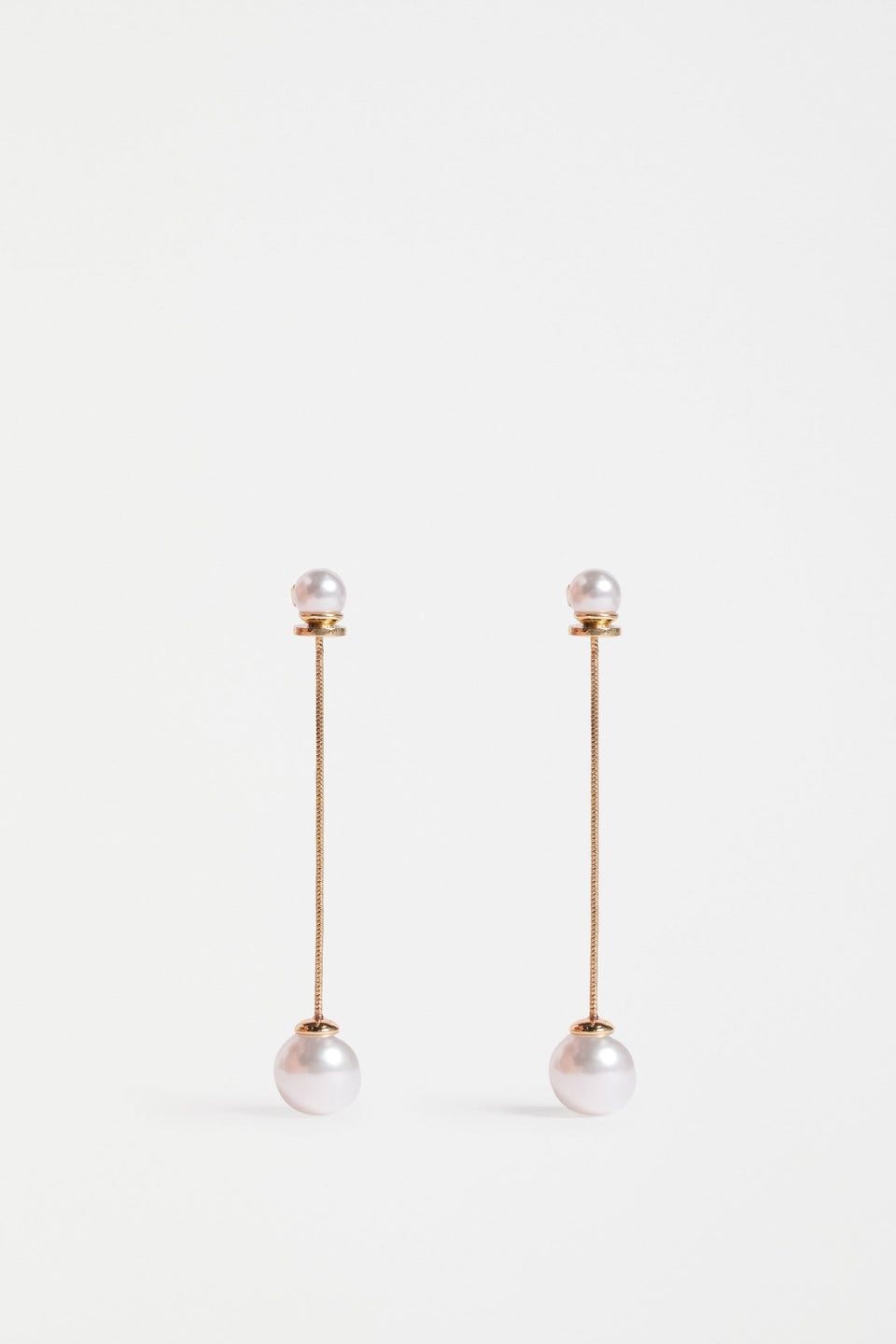 The Sarra Drop Earring features a slender chain with a small bead at the ear and a larger bead drop, creating elegant, lightweight movement | GOLD