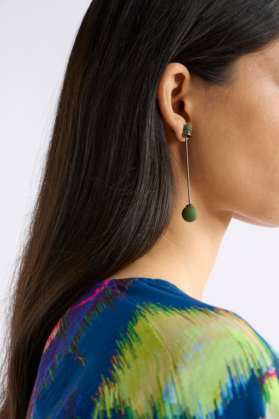 The Sarra Drop Earring features a slender chain with a small bead at the ear and a larger bead drop, creating elegant, lightweight movement, close up on model | GUNMETAL