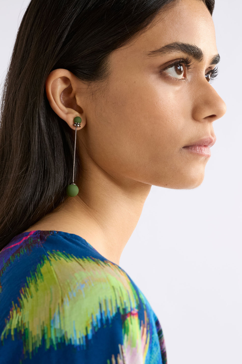 The Sarra Drop Earring features a slender chain with a small bead at the ear and a larger bead drop, creating elegant, lightweight movement, shown on model | GUNMETAL