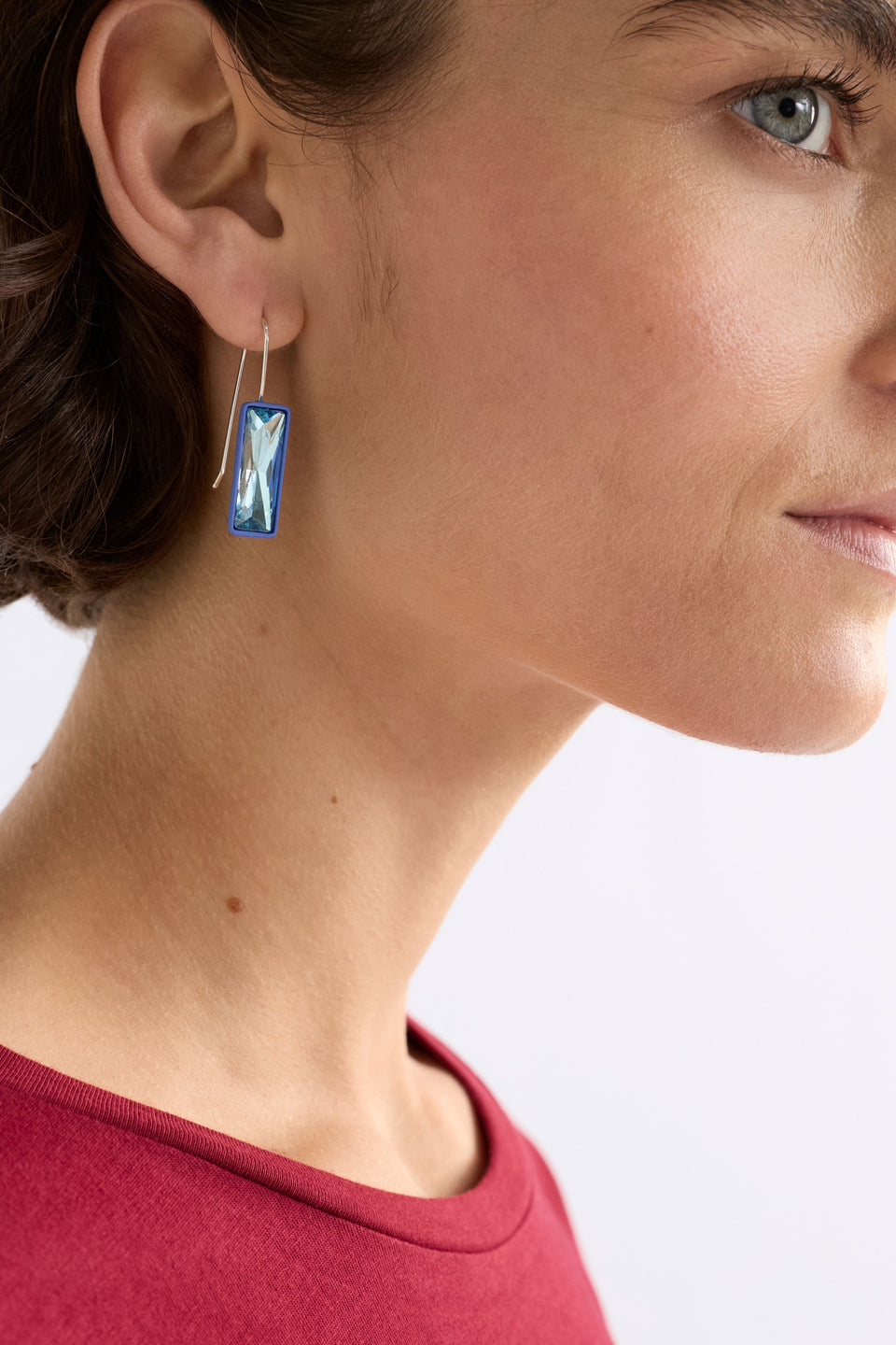 The Jule Small Hook Earring features a single glass stone with tonal rubberised casing and a simple hook, offering lightweight refinement, shown on model | BLUE MIST