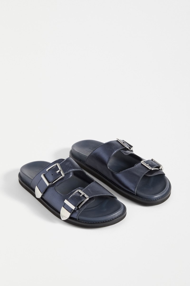 The Spenne Sandal features dual buckled foiled leather straps with tonal western hardware in a metallic slide design ELK | NAVY