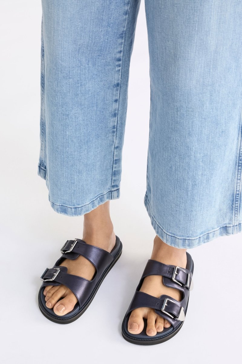 The Spenne Sandal features dual buckled foiled leather straps with tonal western hardware in a metallic slide design ELK | NAVY