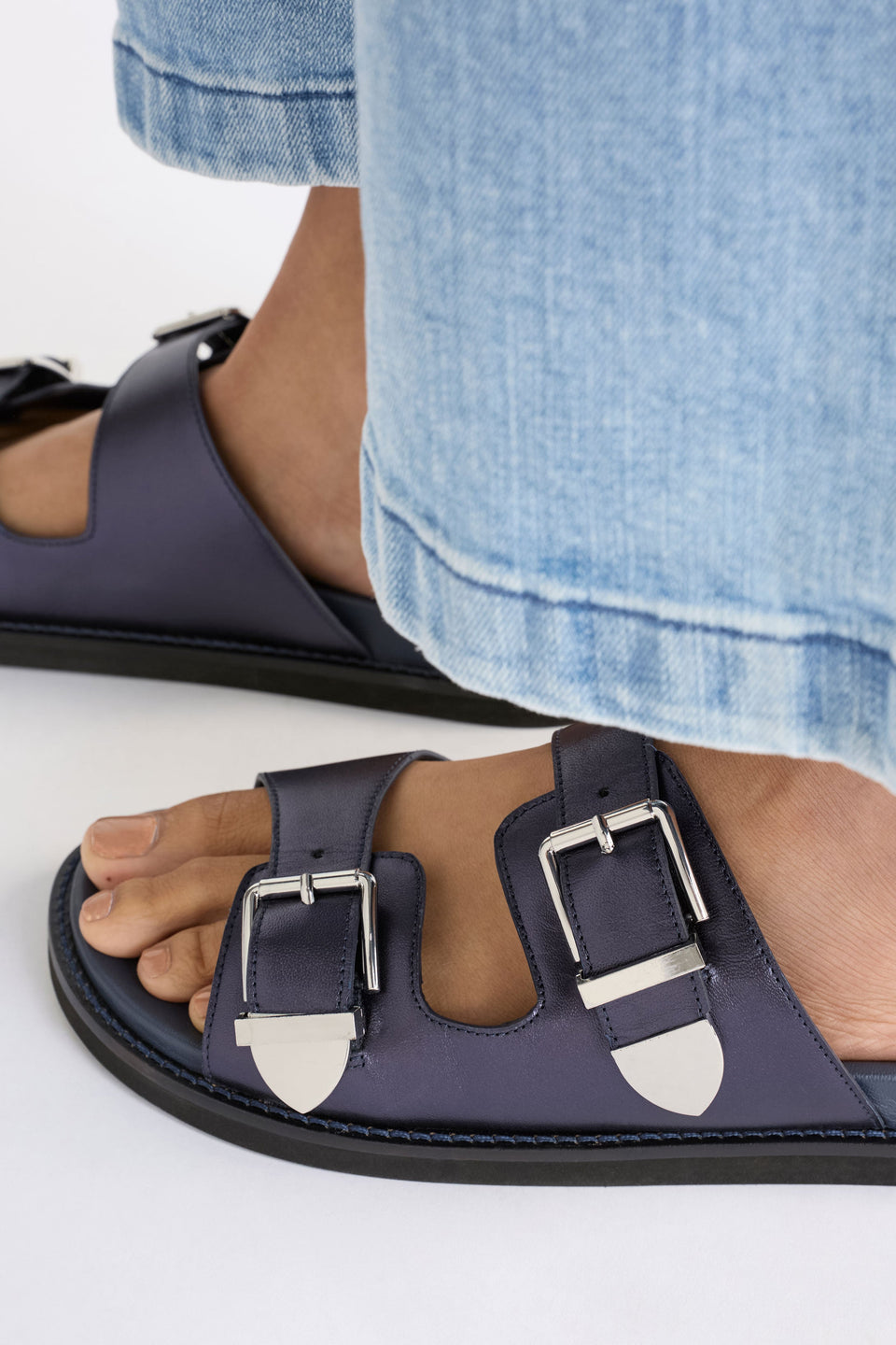 The Spenne Sandal features dual buckled foiled leather straps with tonal western hardware in a metallic slide design ELK | NAVY