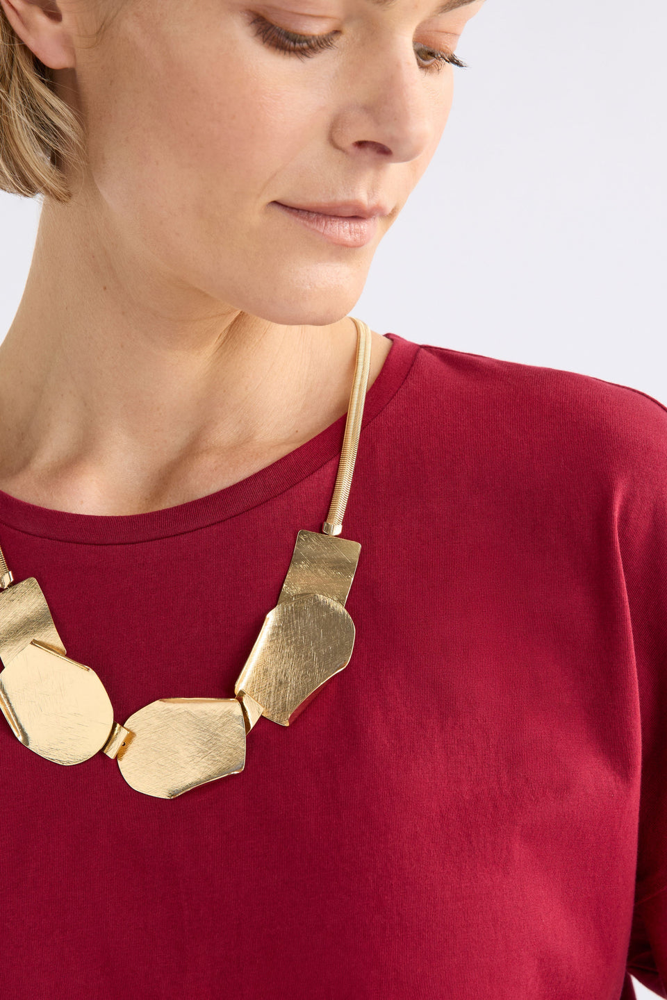 Villt Necklace features sculptural metal shapes with subtle folds and a brushed crosshatched finish for bold, artistic impact on model ELK | GOLD