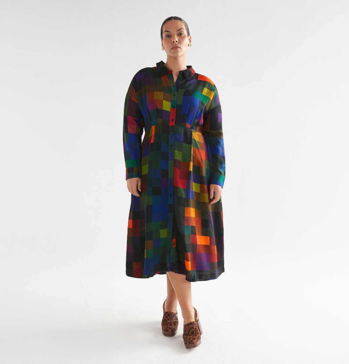 Model wearing a vibrant multicolored checkered button-down midi dress with leopard print heels.