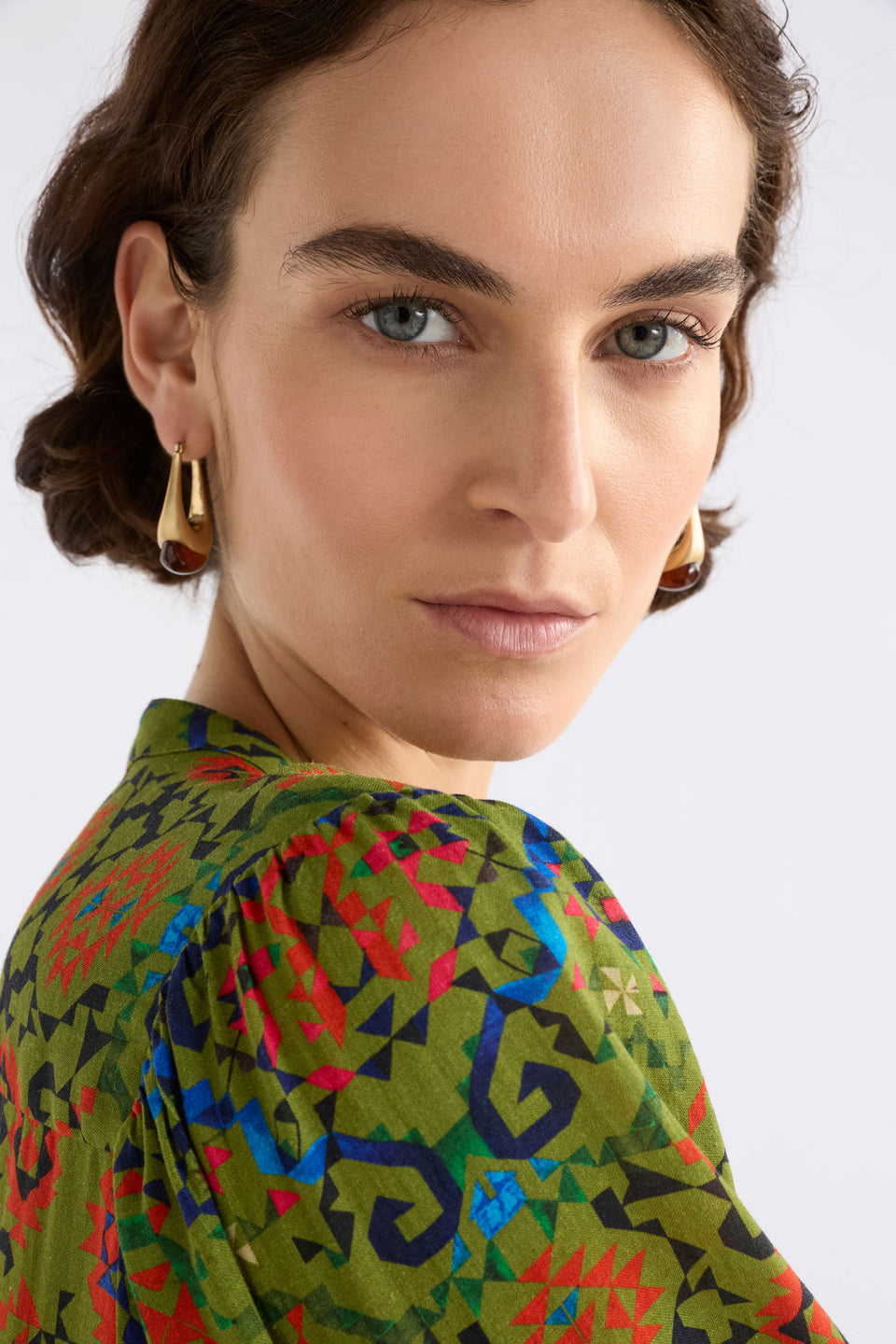 The Korvvo Long Hoop Earring features a sculptural elongated hoop with dramatic length, finished with a chunky flecked glass bead ELK | RED