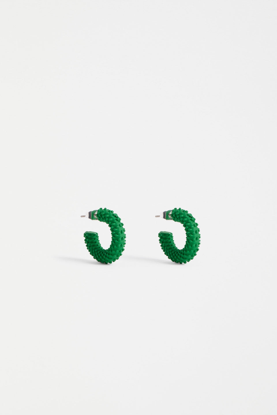 The Ekstaa Mini Hoop Earring features a textured small hoop design with a soft matte rubberised finish in bold colourways ELK | ALOE GREEN