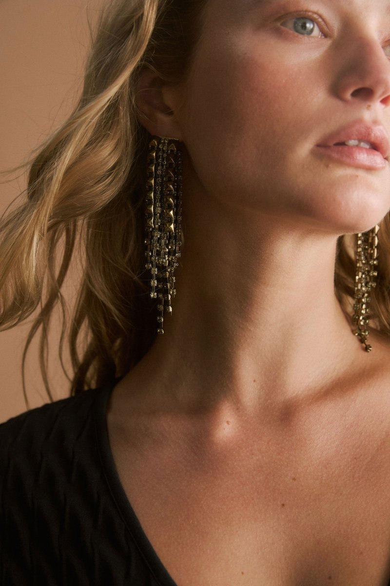 The Rutor Earring features dramatic long drops with tonal diamante chains and metallic studs in varied lengths for high-impact shine on model ELK | OLIVE