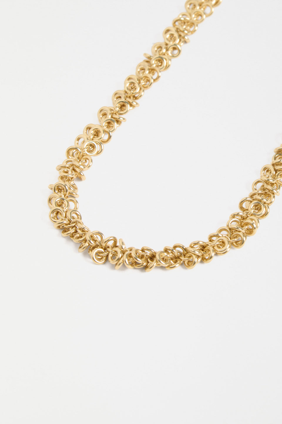 The Hava Necklace features layered metallic jump rings forming a thick, textured chain with sculptural impact ELK | GOLD