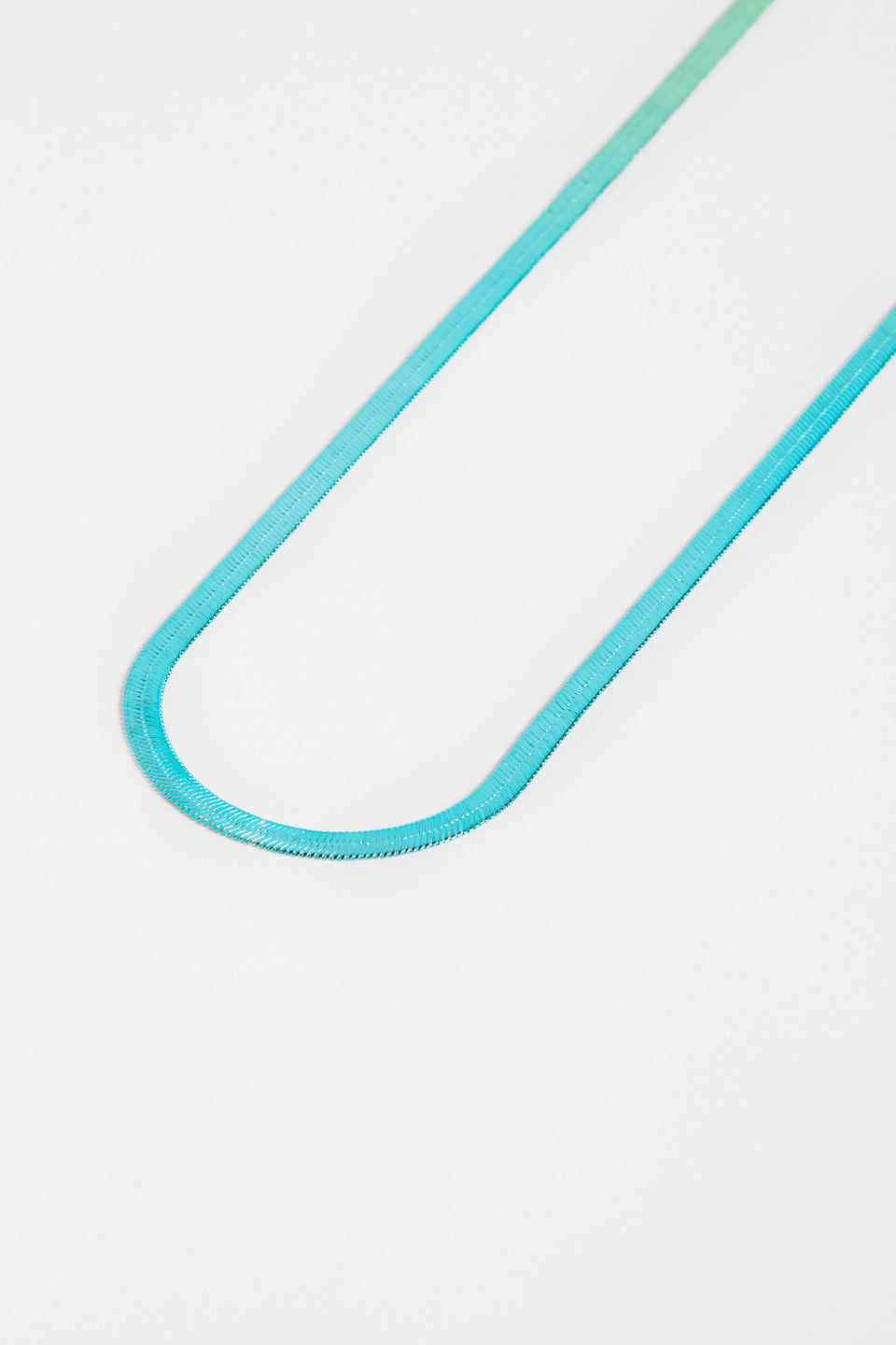 The Vera Long Necklace features a wide, flat snake chain in a shiny ombré finish, adding glistening colour and movement to any look ELK | GREEN-BLUE OMBRE