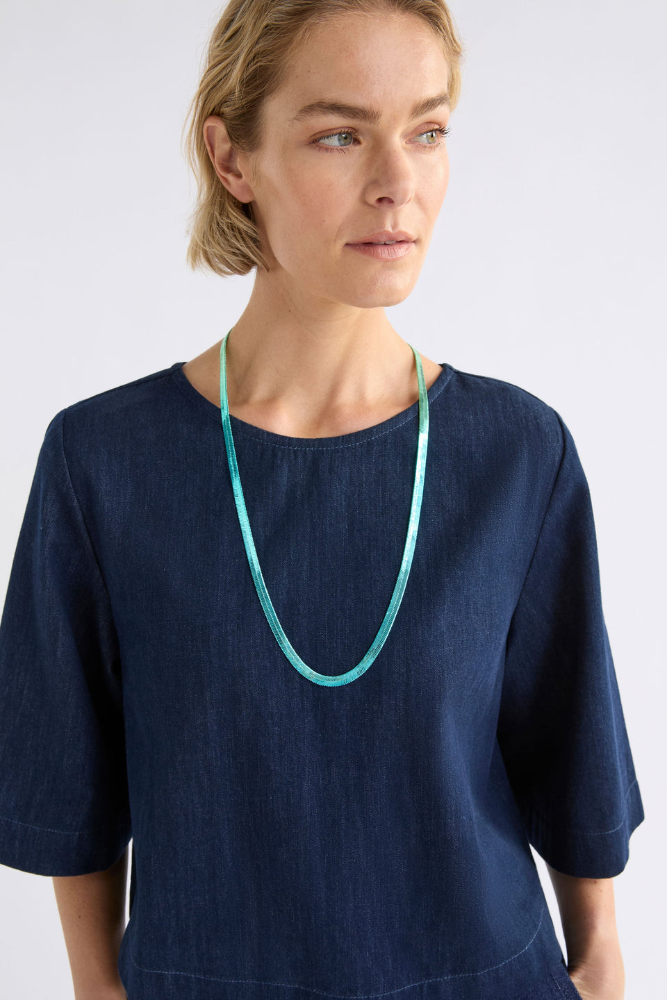 The Vera Long Necklace features a wide, flat snake chain in a shiny ombré finish, adding glistening colour and movement to any look ELK | GREEN-BLUE OMBRE