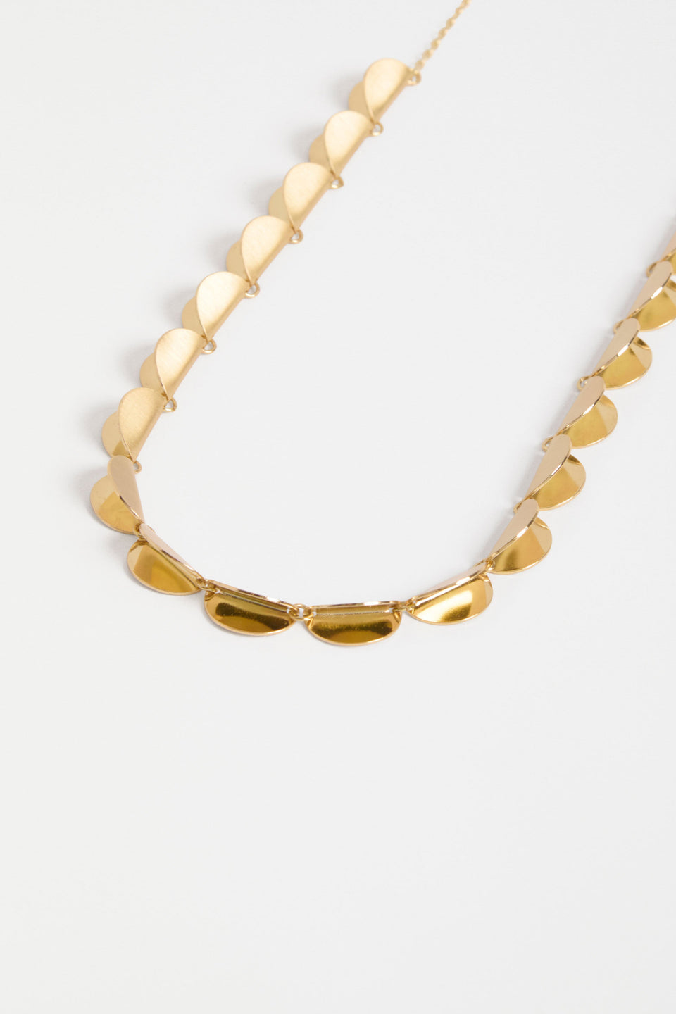 The Fossen Necklace features a row of brushed metal folded discs linked with jump rings on a fine chain ELK | GOLD