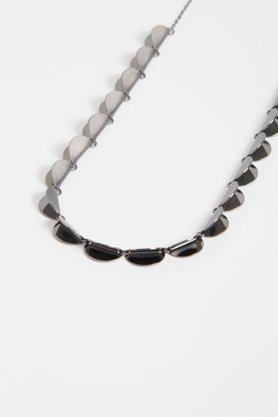 The Fossen Necklace features a row of brushed metal folded discs linked with jump rings on a fine chain ELK | GUNMETAL